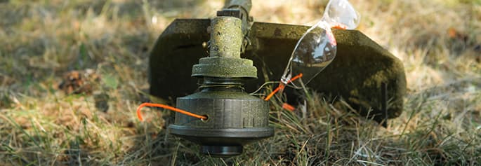 Photographie d'une personne réparant un moteur de tondeuse